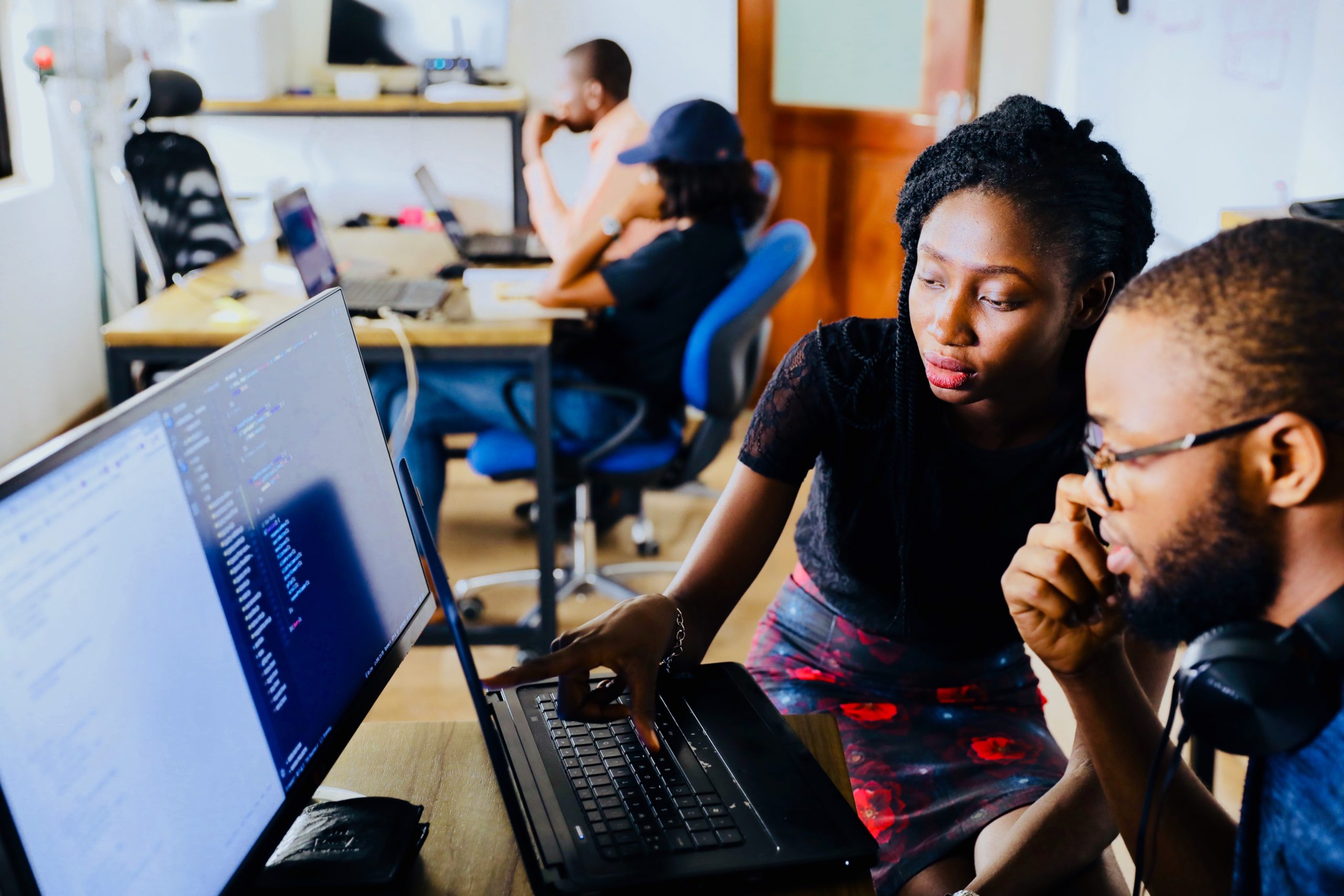 female student helping another male student at a computer